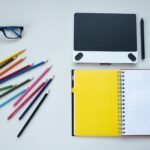 Crafting Captivating Headlines: Your awesome post title goes here Flat lay of a creative workspace featuring colored pencils, notebook, and graphic tablet.
